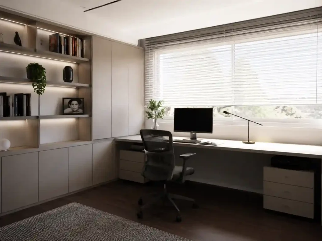 Home office com secretária, estantes e armários por medida em madeira clara e luz natural.